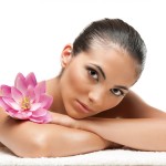 Young beautiful woman relaxing with lotus flower at spa isolated on white background, professional beauty makeup